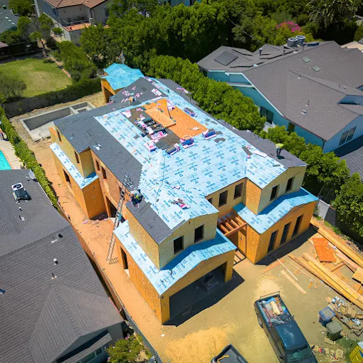 Roofing team progressing through installation details on a large home